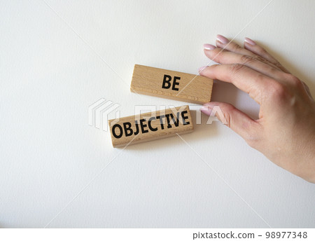 Be Objective symbol. Wooden blocks with words Be Objective. Businessman hand. Beautiful white background. Business and Be Objective concept. Copy space. 98977348