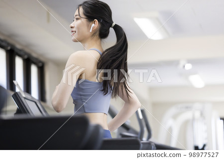 在健身房的跑步機上跑步的年輕女子 98977527