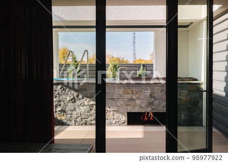 View from inside of modern hot tub. Bonfire under tube warming water. Luxury resort View from inside of modern hot tub. Bonfire under tube warming water. Luxury resort 98977922