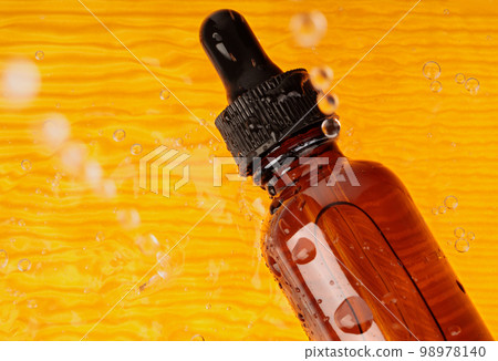 A yellow background with essential oil in water. Aromatherapy as a concept. natural remedies, health preservation. Concept of scents and aromatherapy. A yellow background with essential oil in water. Aromatherapy as a concept. natural remedies, health preservation. Concept of scents and aromatherapy. 98978140