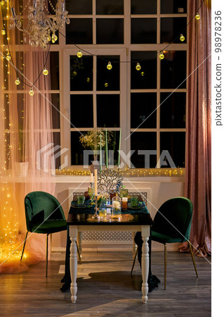 Romantic dinner table setting with festive lights 98978236