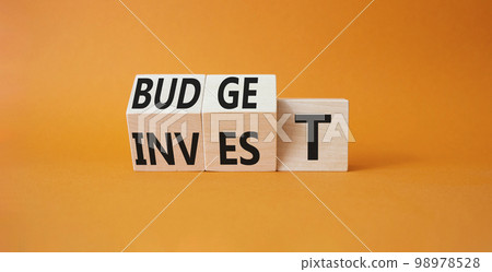 Budget or Invest symbol. Wooden cubes with words Invest and Budget. Beautiful orange background. Business and Budget and Invest concept. Copy space Budget or Invest symbol. Wooden cubes with words Invest and Budget. Beautiful orange background. Business and Budget and Invest concept. Copy space 98978528