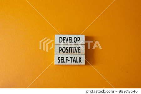Develop positive self-talk symbol. Concept words Develop positive self-talk on wooden blocks. Beautiful orange background. Business and Develop positive self-talk concept. Copy space 98978546