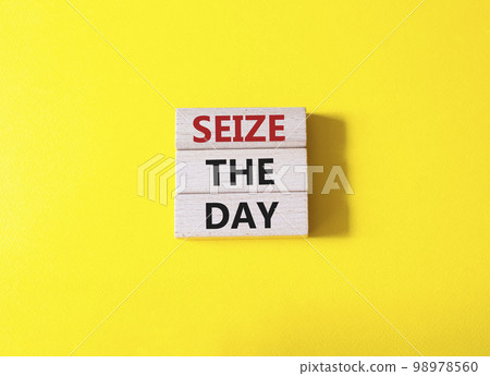Seize the day symbol. Wooden blocks with words Seize the day. Beautiful yellow background. Business and Seize the day concept. Copy space. 98978560