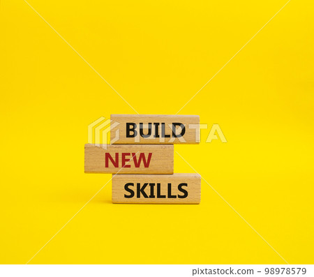 Build New skills symbol. Concept word Build New skills on wooden blocks. Beautiful yellow background. Business and Build New skills concept. Copy space 98978579