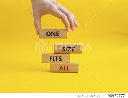 One size fits all symbol. Concept words One size fits all on wooden blocks. Beautiful yellow background. Businessman hand. Business and One size fits all concept. Copy space. 98979777