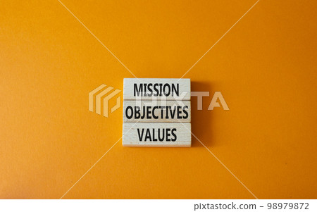 Mission Objectives Values symbol. Concept words Mission Objectives Values on wooden blocks. Beautiful orange background. Business and Mission Objectives Values concept. Copy space 98979872