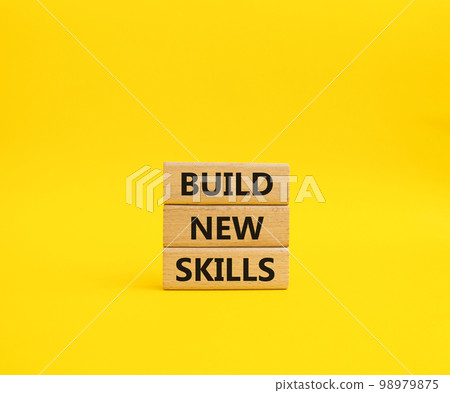 Build New skills symbol. Concept word Build New skills on wooden blocks. Beautiful yellow background. Business and Build New skills concept. Copy space Build New skills symbol. Concept word Build New skills on wooden blocks. Beautiful yellow background. Business and Build New skills concept. Copy space 98979875