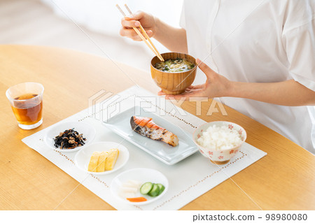 Young woman eating breakfast 98980080