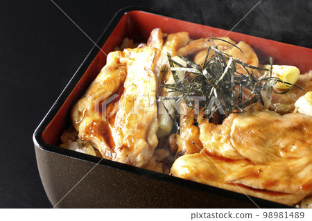 Hot charcoal-grilled yakitori with plenty of sauce, photographed against a black background 98981489