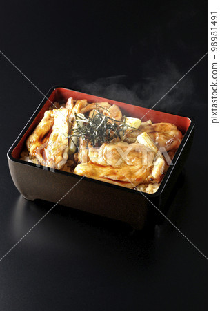 Hot charcoal-grilled yakitori with plenty of sauce, photographed against a black background 98981491