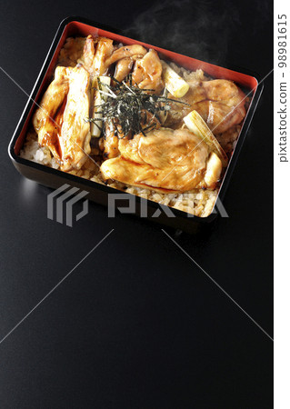 黑色背景上的熱炭烤烤雞肉串的頭頂照片，上面有很多醬汁 98981615