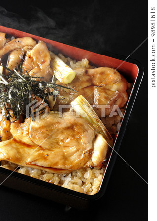 黑色背景上的熱炭烤烤雞肉串的頭頂照片，上面有很多醬汁 98981618