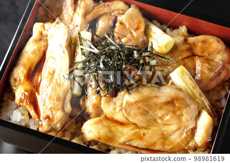 黑色背景上的熱炭烤烤雞肉串的頭頂照片，上面有很多醬汁 98981619