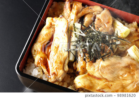 黑色背景上的熱炭烤烤雞肉串的頭頂照片，上面有很多醬汁 98981620