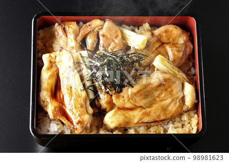 黑色背景上的熱炭烤烤雞肉串的頭頂照片，上面有很多醬汁 98981623