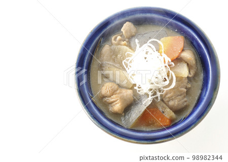 A bird's-eye view of a hot pork offal stew with carrots, konjac, burdock, and radish on a white background 98982344