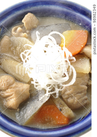 A bird's-eye view of a hot pork offal stew with carrots, konjac, burdock, and radish on a white background A bird's-eye view of a hot pork offal stew with carrots, konjac, burdock, and radish on a white background 98982349