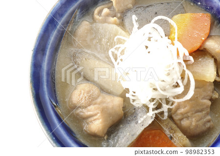 A bird's-eye view of a hot pork offal stew with carrots, konjac, burdock, and radish on a white background 98982353