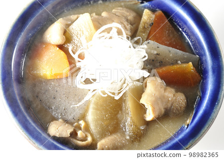 A bird's-eye view of a hot pork offal stew with carrots, konjac, burdock, and radish on a white background A bird's-eye view of a hot pork offal stew with carrots, konjac, burdock, and radish on a white background 98982365