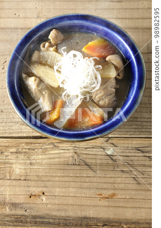 A bird's-eye view of hot pork offal stew with carrots, konjac, burdock, and radish 98982595