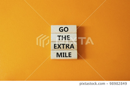 Go the extra mile symbol. Wooden blocks with words Go the extra mile. Beautiful orange background. Business and Go the extra mile concept. Copy space. Go the extra mile symbol. Wooden blocks with words Go the extra mile. Beautiful orange background. Business and Go the extra mile concept. Copy space. 98982849