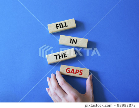 Fill in the gaps symbol. Concept words fill in the gaps on wooden blocks. Beautiful blue background. Business and fill in the gaps concept. Copy space. Fill in the gaps symbol. Concept words fill in the gaps on wooden blocks. Beautiful blue background. Business and fill in the gaps concept. Copy space. 98982872