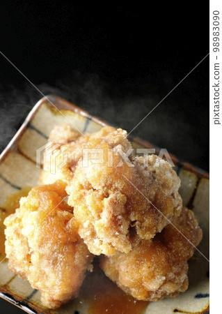 A bird's-eye view of hot chicken Tatsuta-age with grated ponzu sauce on a black background 98983090