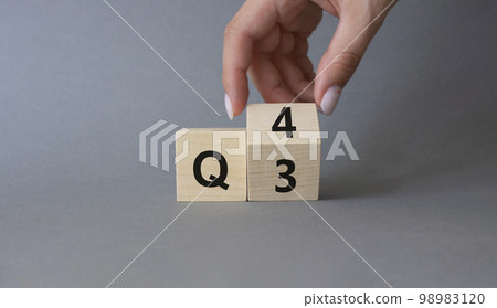 From 3rd Quarter to 4th symbol. Businessman hand Turnes cube and changes words 3rd Quarter to 4th Quarter. Beautiful grey background. Business and Quarter concept. Copy space 98983120