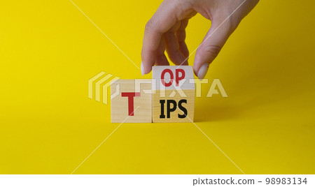 Top Tips symbol. Businessman hand Turnes cubes with words Top Tips. Beautiful yellow background. Business and Top Tips concept. Copy space Top Tips symbol. Businessman hand Turnes cubes with words Top Tips. Beautiful yellow background. Business and Top Tips concept. Copy space 98983134