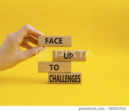 Face up to challenges symbol. Wooden blocks with words Face up to challenges. Beautiful yellow background. Businessman hand. Business and Face up to challenges concept. Copy space. Face up to challenges symbol. Wooden blocks with words Face up to challenges. Beautiful yellow background. Businessman hand. Business and Face up to challenges concept. Copy space. 98983430