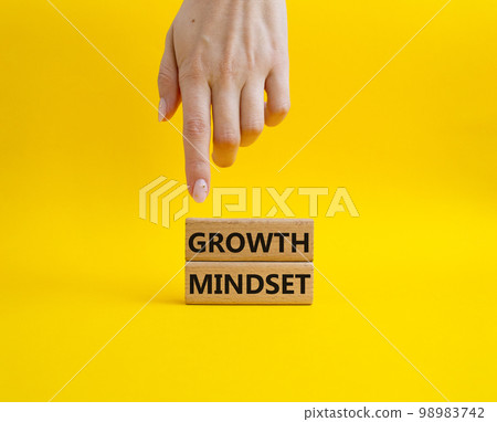 Growth Mindset symbol. Concept word Growth Mindset on wooden blocks. Beautiful yellow background. Businessman hand. Business and Growth Mindset concept. Copy space 98983742