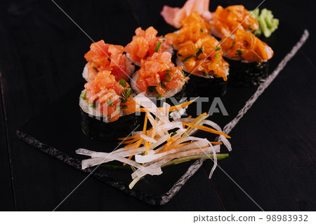 sushi maki rolls with sliced salmon on top sushi maki rolls with sliced salmon on top 98983932