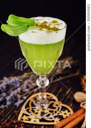 Fresh basil sour cocktail with white foam with green basil leaf in a glass 98984063