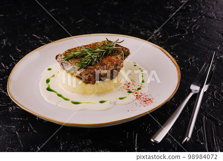 steak with rosemary on mashed potatoes steak with rosemary on mashed potatoes 98984072