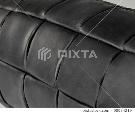 Closeup of bolster pillow from patches of black genuine leather Closeup of bolster pillow from patches of black genuine leather 98984219