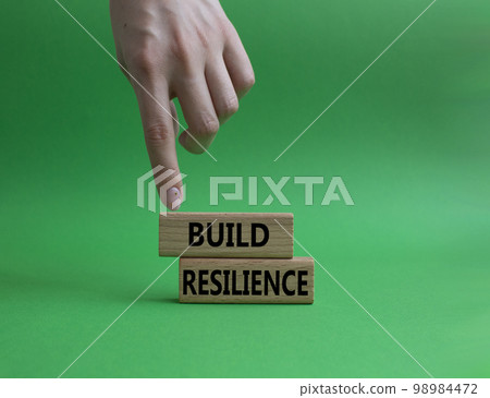 Build resilience symbol. Wooden blocks with words Build resilience. Beautiful green background. Businessman hand. Business and Build resilience concept. Copy space. 98984472
