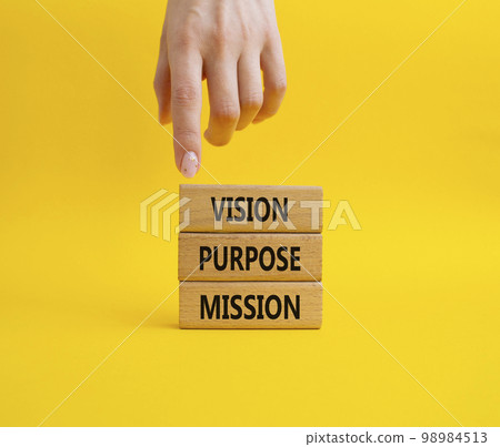 Vision Purpose Mission symbol. Concept word Vision Purpose Mission on wooden blocks. Beautiful yellow background. Businessman hand. Business and Vision Purpose Mission concept. Copy space. 98984513