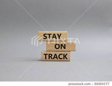 Stay on track symbol. Wooden blocks with words Stay on track. Beautiful grey background. Business and Stay on track concept. Copy space 98984577