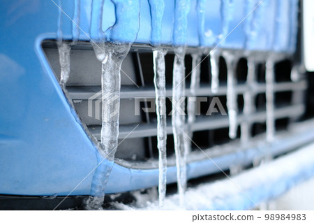 Icicles on the front bumper of a blue car 98984983