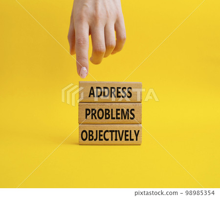 Address Problems Objectively symbol. Wooden blocks with words Address Problems Objectively. Beautiful yellow background. Businessman hand. Business and Address Problems Objectively concept. Copy space 98985354