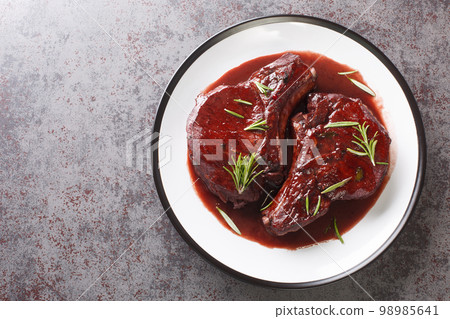 Maiale ubriaco is a traditional Tuscan dish simmered pork chops with red wine closeup on the plate. Horizontal top view 98985641