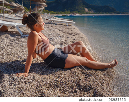 Cheerful woman enjoying the beach 98985833