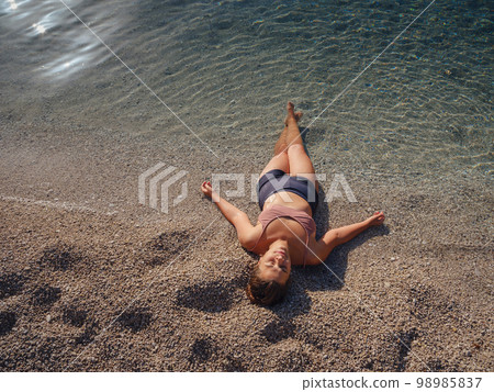 Cheerful woman enjoying the beach 98985837