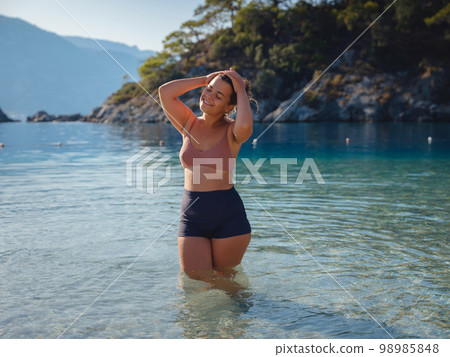 Cheerful woman enjoying the beach 98985848