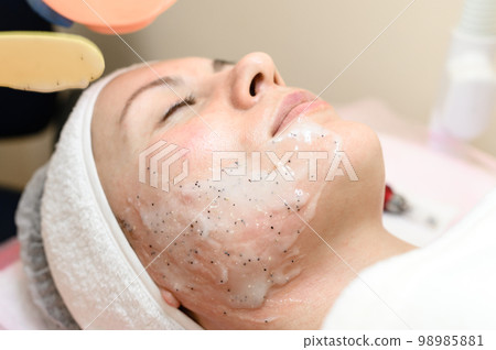 The process of applying a moisturizing mask to the face in a spa salon. 98985881