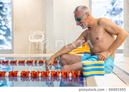 Senior swimmer in watersports goggles at the swimming pool 98985995