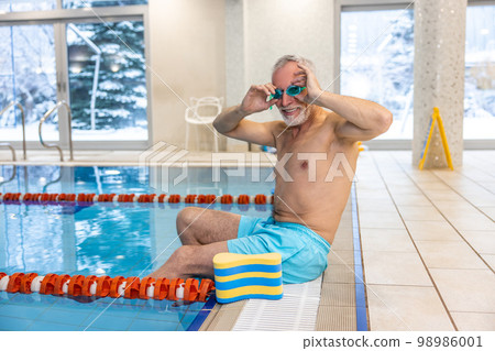 Senior swimmer in watersports goggles at the swimming pool Senior swimmer in watersports goggles at the swimming pool 98986001