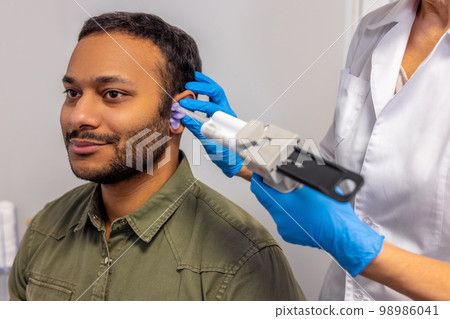 ENT doctor examining the patient with the medical apparatus 98986041