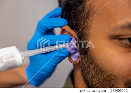 ENT doctor examining the patient with the medical apparatus 98986042